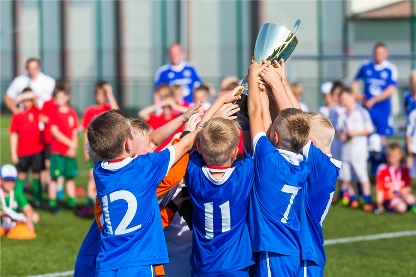 מאמר סקירה הסיק כי אוקסיטוצין מווסת פחד וחרדה ומאפשר לפתח אמון במיוחד עם מי שמסווגים כשייכים לקבוצה. ילדים בקבוצת ספורט מניפים גביע | matimix, Shutterstock