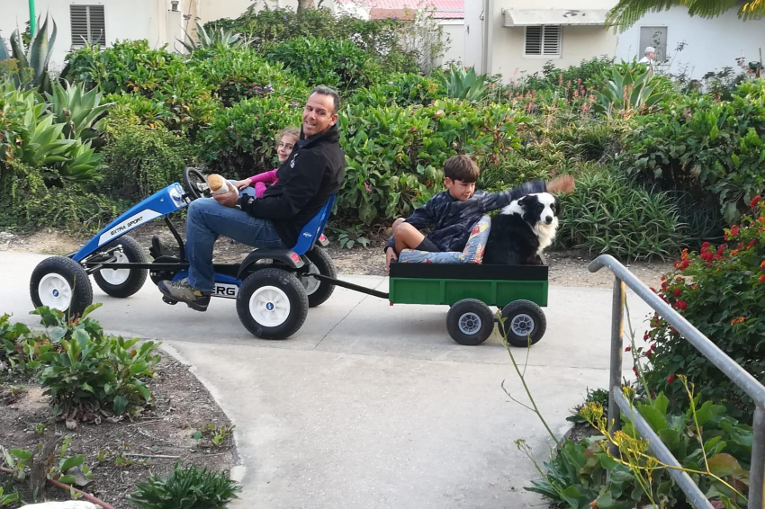 המשפחה הייתה כל עולמו. אוהד מדווש בשבילי ניר עוז עם הבת יעל, ועם איתן והכלבה פולי בעגלה | צילום: באדיבות המשפחה