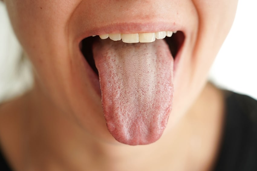 על הלשון מפוזרים קולטנים החשים בחמישה טעמים שונים. ילדה חורצת לשון | Mariia Kurlova, Shutterstock