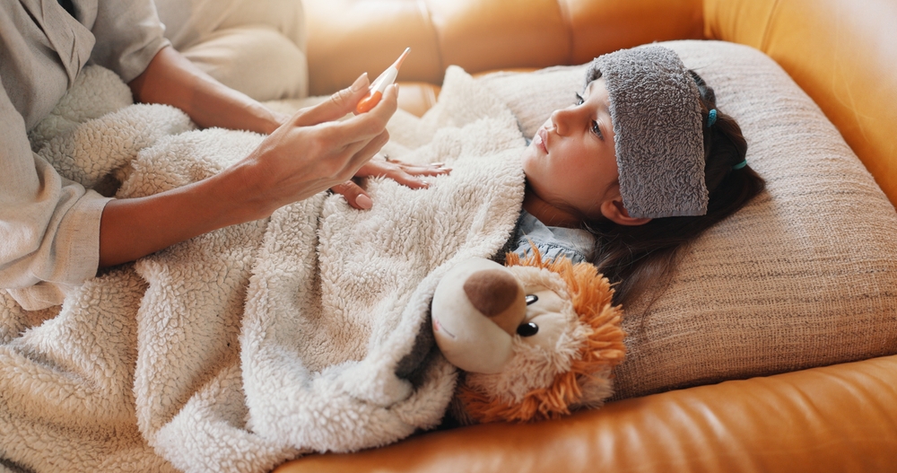 העלייה בפניות למרפאות בגלל מחלות דמויות שפעת החלה מוקדם מהרגיל. אמא מודדת חום לילד חולה | Shutterstock, PeopleImages