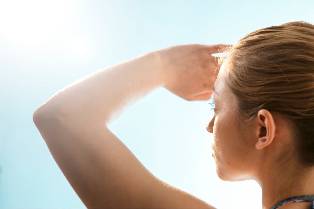 חשיפה לקרני השמש, גם בחורף, מגדילה את הסיכון למחלות ונזקים בעין. אישה מצילה על פניה | SCIENCE PHOTO LIBRARY