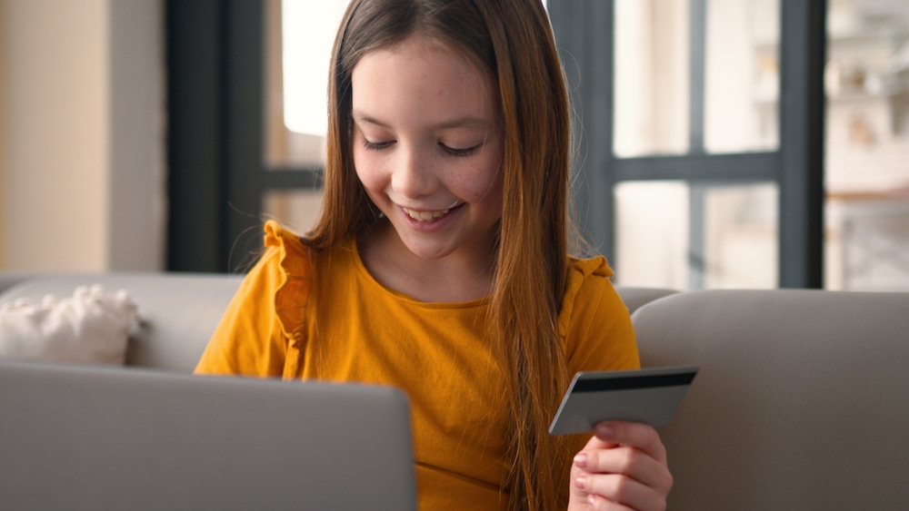 כל התכנון של המשחק מבוסס על כך שהילדים יקנו דברים בעזרת מטבע וירטואלי בשם רוֹבּאקס (Robux). ילדה רוכשת פריטים במשחק מחשב באמצעות כרטיס אשראי | MAYA LAB, Shutterstock