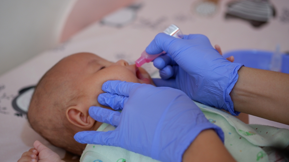 לאחר קבלת החיסון, הנגיף המוחלש, שלא יכול להזיק לבני אדם, מתרבה במעיים ומופרש בצואה. תינוק מקבל חיסון מוחלש נגד פוליו | Wisely, Shutterstock