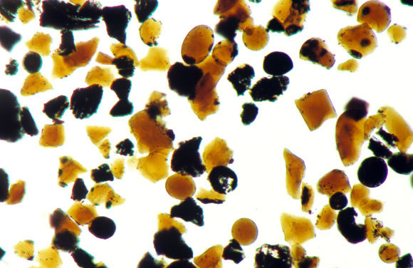 כמעט שליש מהחול על הירח מורכב מגבישי זכוכית, האוצרים כנראה את המים. צילום מיקרוסקופי של דגימת חול שהביאה החללית אפולו 17 | מקור: NASA / SCIENCE PHOTO LIBRARY