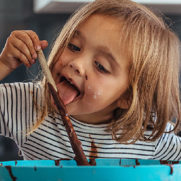 הטעם המתוק מאותת שבמזון יש הרבה אנרגיה אך בתזונה המערבית המודרנית צריכת יתר של סוכר הפכה לבעיית בריאות. ילדה מלקקת בלילה מתוקה | Jacob Lund, Shutterstock