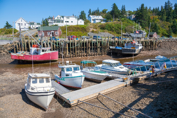 At low tide the boats rest at the bottom. A dock at the Bay of Fundy, where the difference between high and low tide is the largest in the world | Image: Noel V. Baebler, Shutterstock