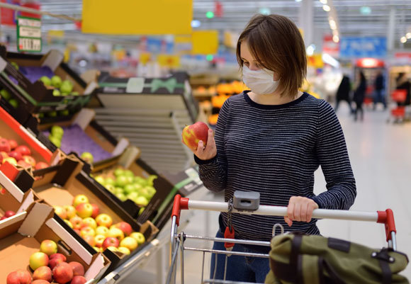 امرأة مع كمامة وقائيّة في السّوبر ماركت. صورة: Maria Sbytova, Shutterstock