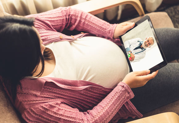 במדינות מסוימות ממליצים לבצע מרחוק חלק מהמעקב. אישה הרה מתייעצת עם רופא בשיחת וידאו | צילום: Blue Planet Studio, Shutterstock